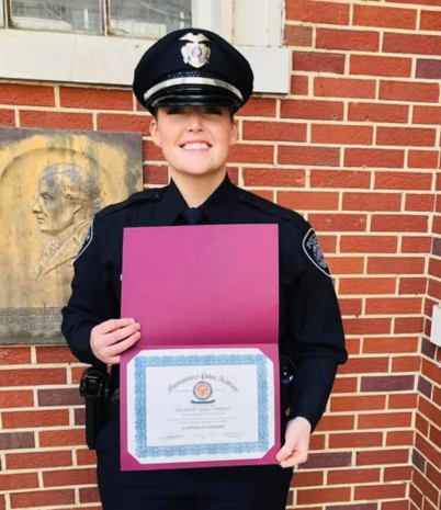 Pelham Police Officer Elizabeth Minter is shown in dress uniform holding a certificate.